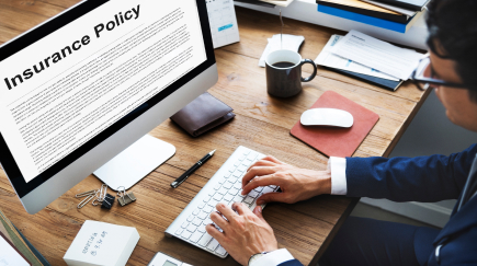 Business handshake over legal documents, symbolizing General Liability Insurance protection.